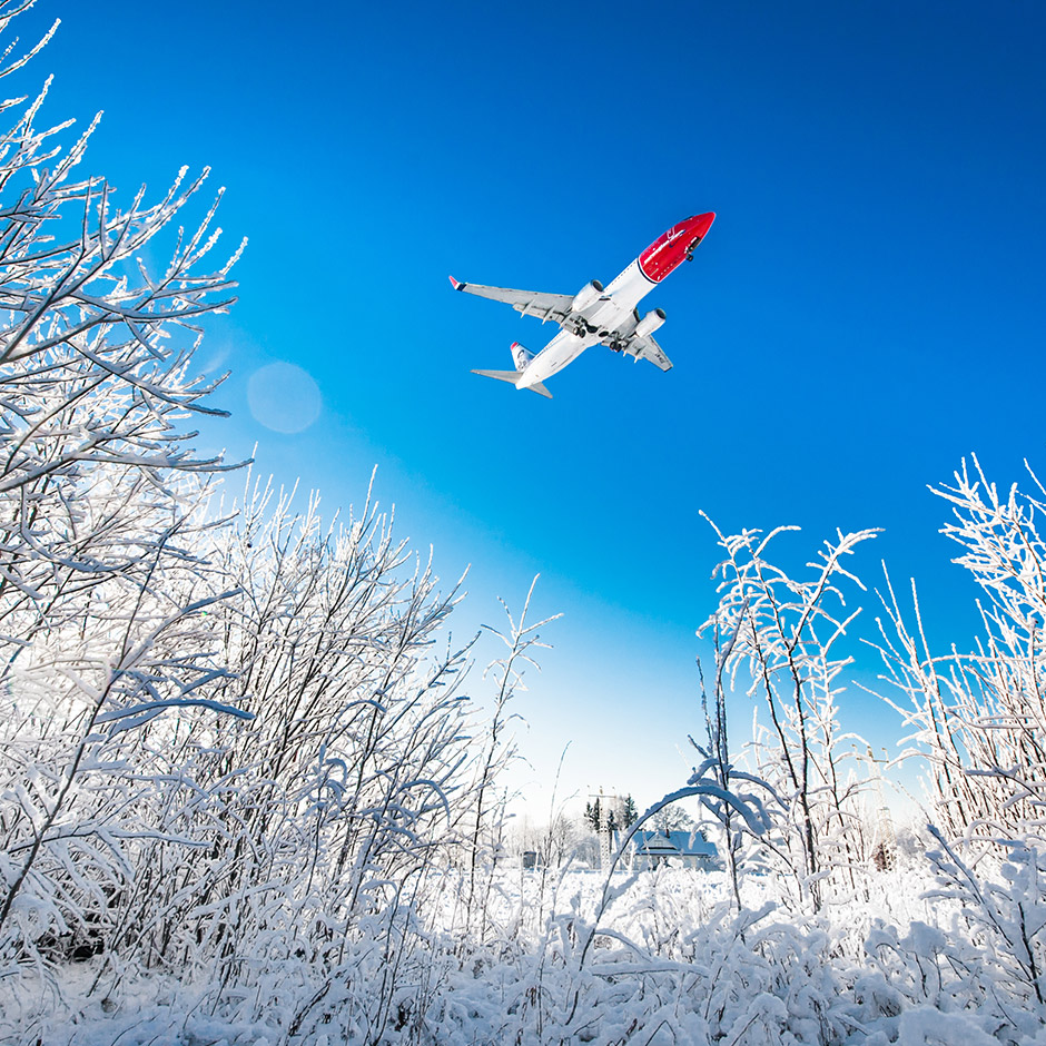 Norwegian plane flying over snow-covered field